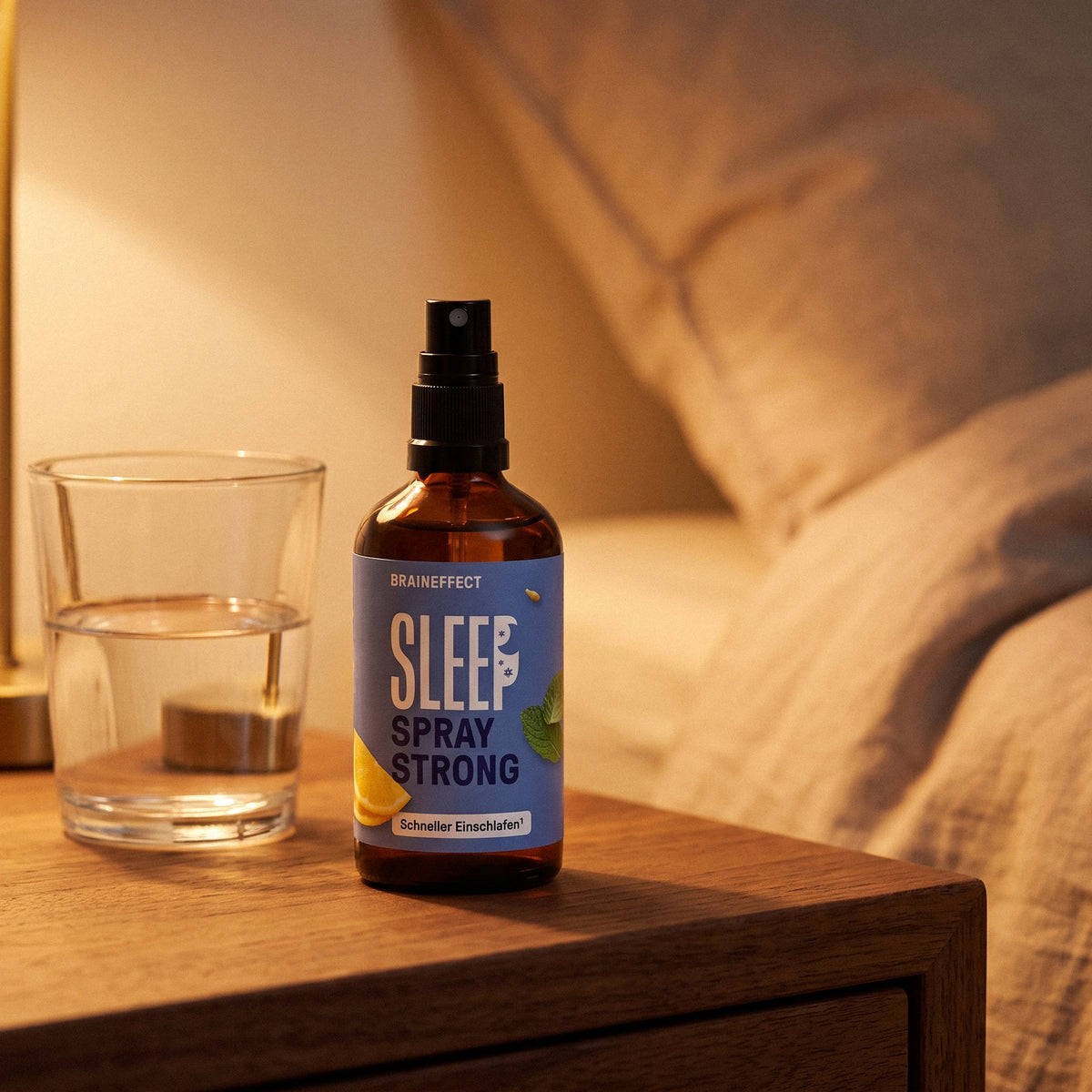BRAINEFFECT SLEEP SPRAY STRONG Schneller Einschlafen auf einem Nachttisch mit einem Glas Wasser im warmen Licht.