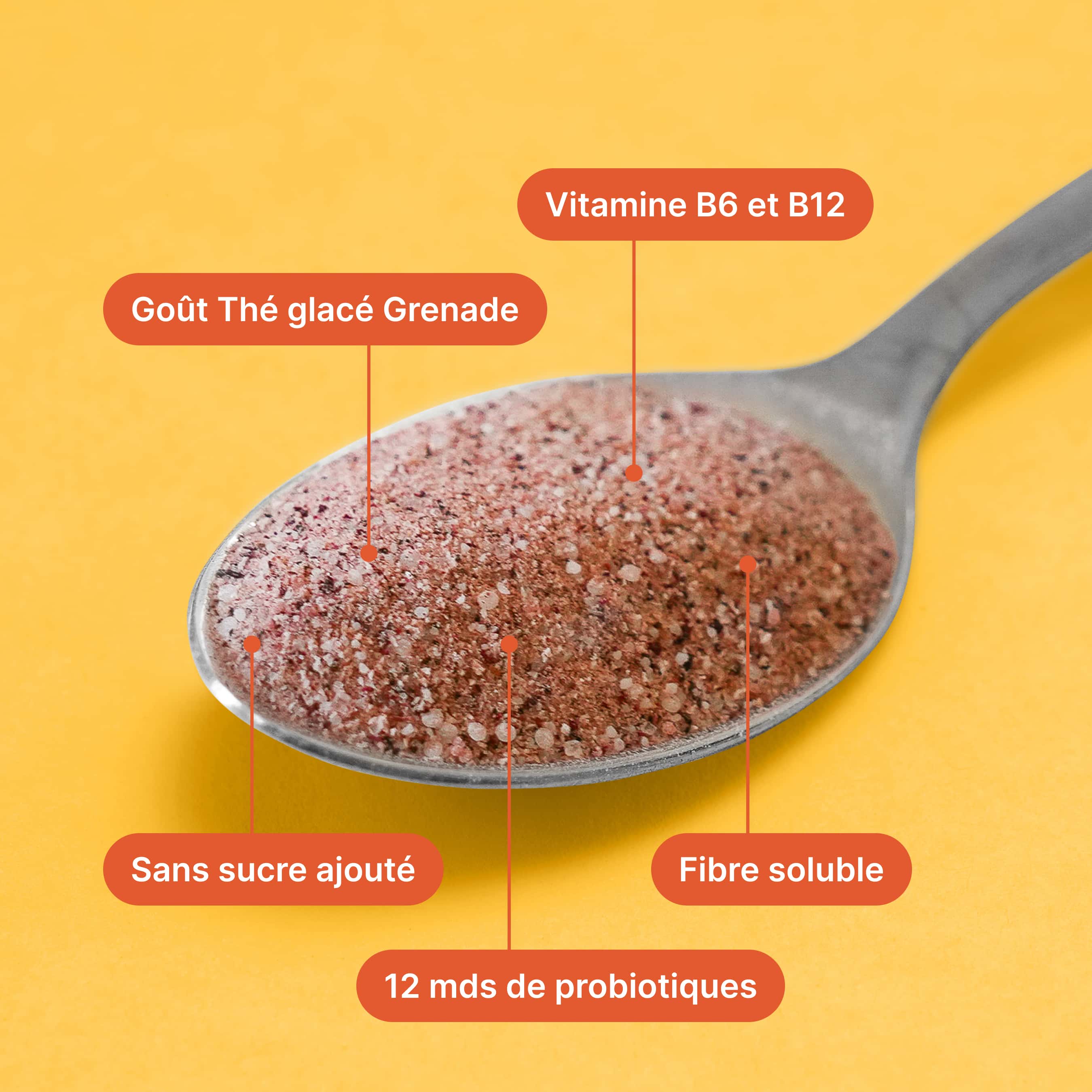 Ein Löffel mit pulvrigem Granatapfel-Eistee-Geschmack, angereichert mit Vitaminen und Probiotika, auf gelbem Hintergrund.
