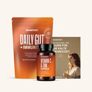 Paket mit Daily Gut + Immunity Pulver, Vitamin C & Zink Kapseln, und einem saisonalen Guide in warmen Tönen.