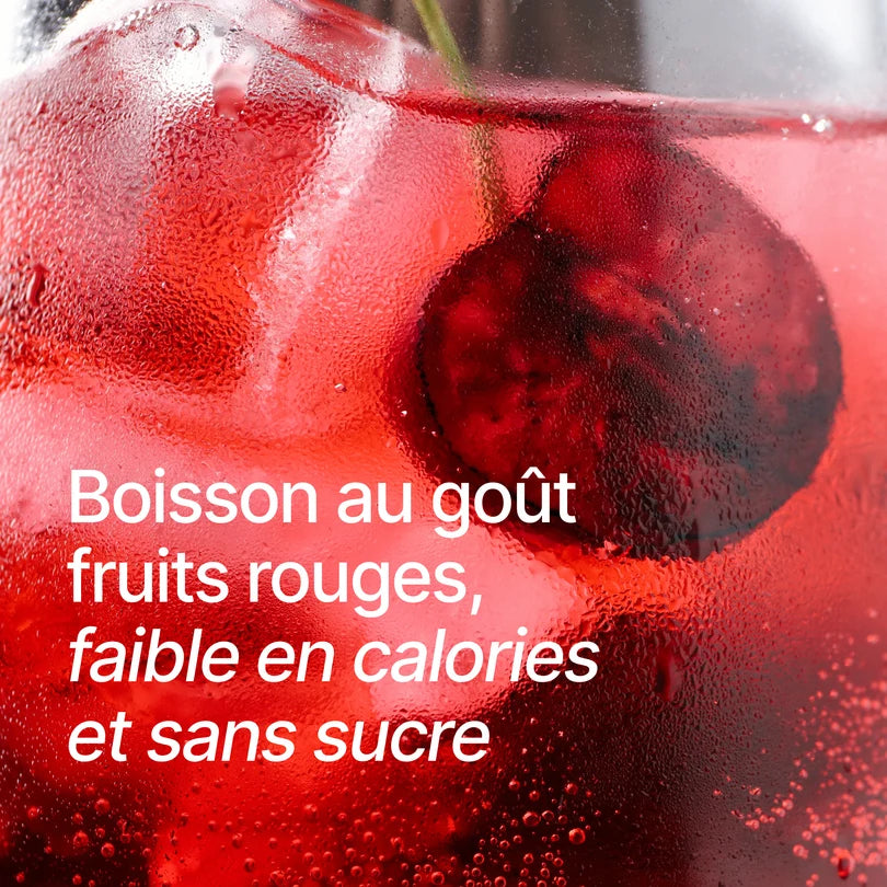 Gros plan sur une boisson rouge glacée avec des glaçons et des morceaux de fruits dans un verre givré, accompagné du texte "Boisson au goût fruits rouges, faible en calories et sans sucre"