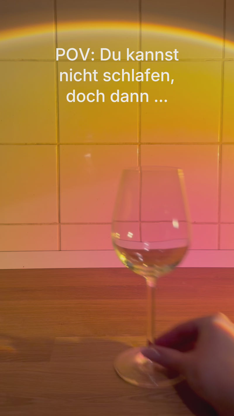 Das Textvideo zeigt den Text "POV: Du kannst nicht schlafendoch dann ..." vor einer gefliesten Wand mit warmem Licht und einem leeren Weinglas auf einer Holzoberfläche.